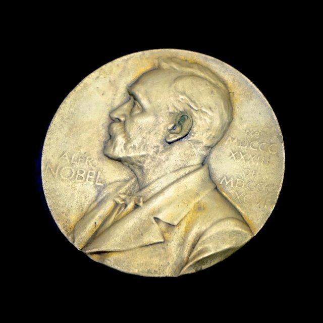 a gold nobel prize medal showing a portrait of a man and the name Alfred Nobel, text worn