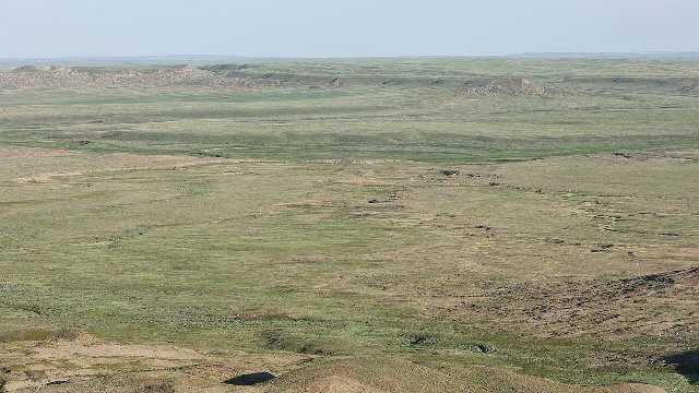 aerial photo showing a flat expanse of low grasslands with some ridges and slightly irregular terrain